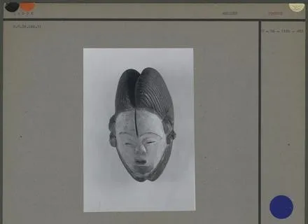 Fiche de photothèque : tirage noir et blanc d’un masque blanc mpongwè à coiffe à coques, monté sur carton gris